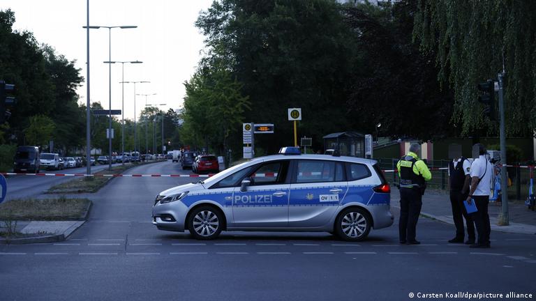 A cordoned-off street with police car