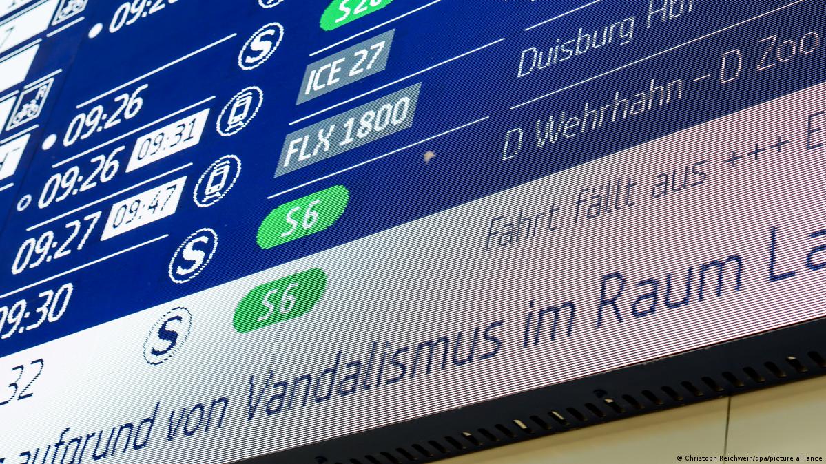 The train departure board at Düsseldorf's main station shows a cancellation due to vandalism on July 11, 2026