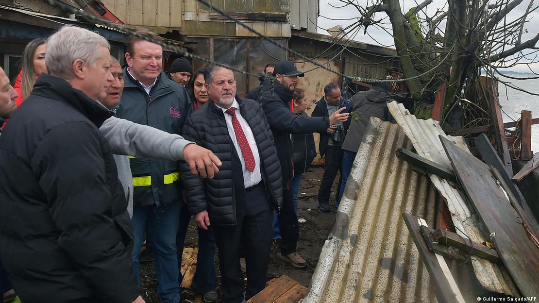 El presidente José Antonio Kast (izquierda en la imagen) conversa con residentes mientras inspecciona los daños causados ​​por las fuertes lluvias en Penco, región de Biobío (17.07.2026)