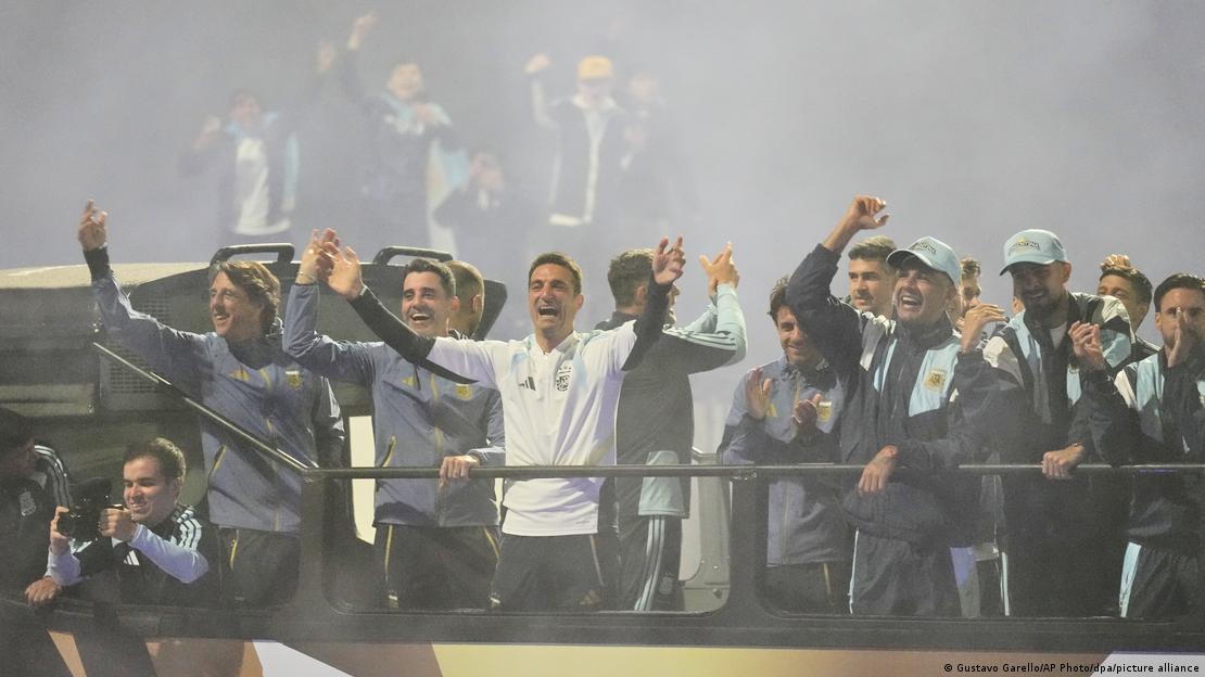 Scaloni y la selección argentina, recibidos en Buenos Aires, celebrando sobre un autobús, en un ambiente con humo.