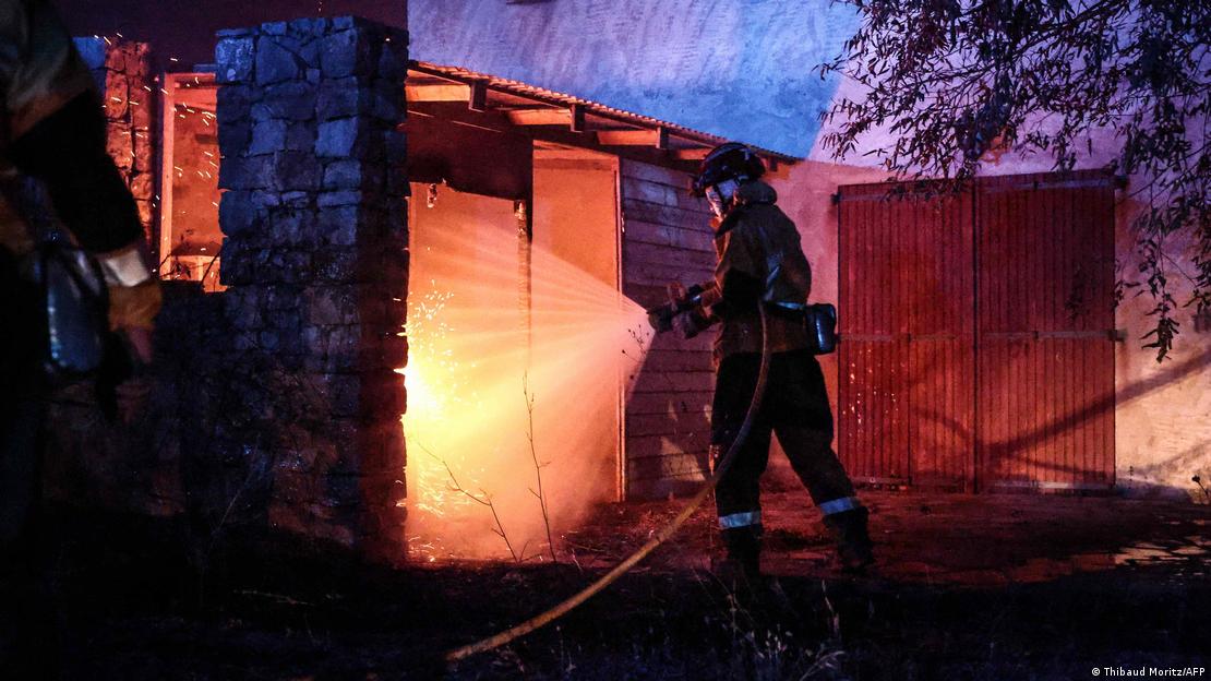 Tek katlı bir yapıdaki alevlere su ile müdahale eden itfaiye personeli Tek katlı bir yapıdaki alevlere su ile müdahale eden itfaiye personeli