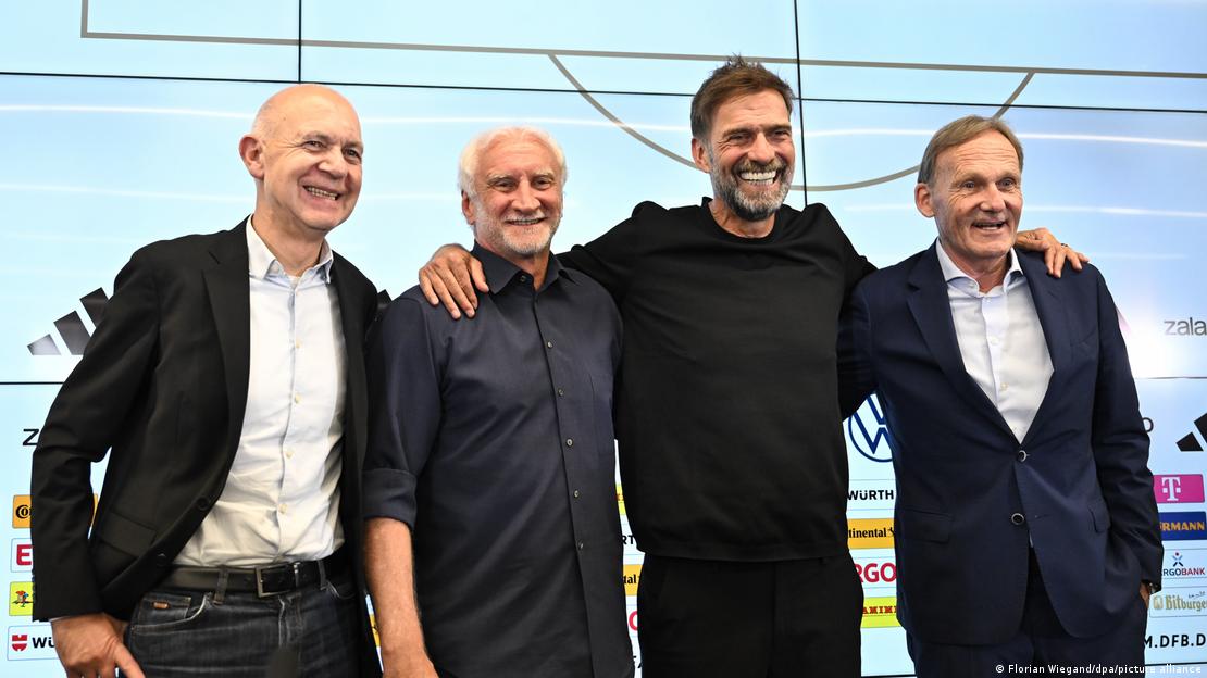 Soldan sağa: Futbol Federasyonu Başkanı Bernd Neuendorf, Spor Direktörü Rudi Völler, Teknik Direktör Jürgen Klopp ve Federasyon Başkan Yardımcısı Hans-Joachim Watzke gülümseyen yüzlerle gazetecilere poz veriyor