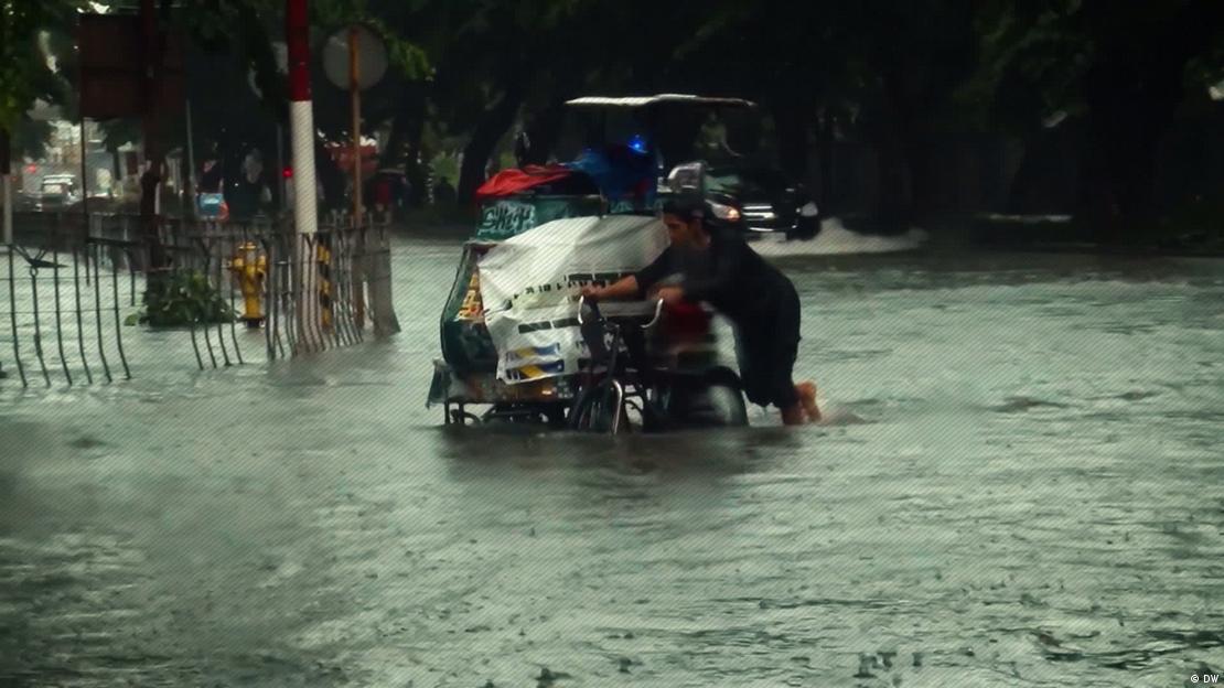 Una persona empuja un carro con sus pertenencias en medio del agua, en una inundación en Manila. (Archivo). Una persona empuja un carro con sus pertenencias en medio del agua, en una inundación en Manila. (Archivo).