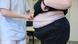 An overweight person being measured