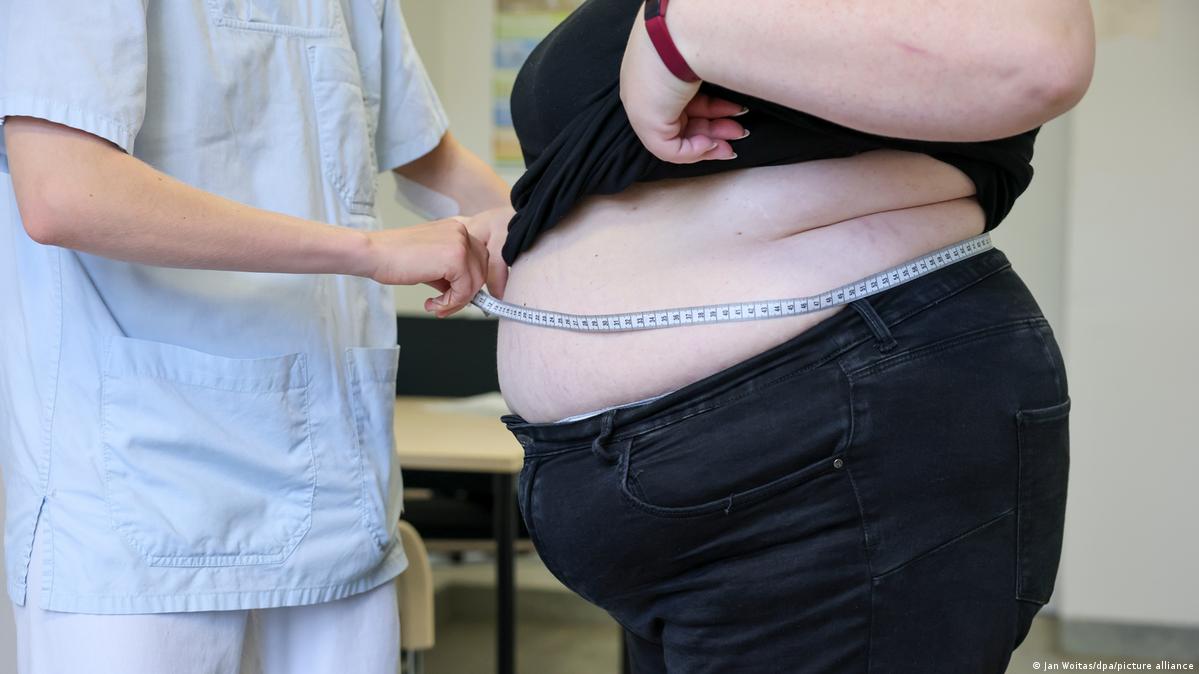 An overweight person being measured