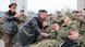 Kim Jong-un abraça um soldado que está sentado em uma cadeira de rodas