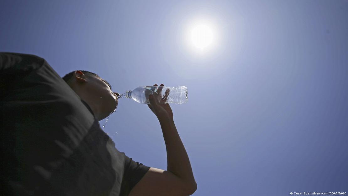 Un hombre toma agua de una botella en Lima, Perú, bajo un sol ardiente, en la ola de calor extremo. (2024). Un hombre toma agua de una botella en Lima, Perú, bajo un sol ardiente, en la ola de calor extremo. (2024).