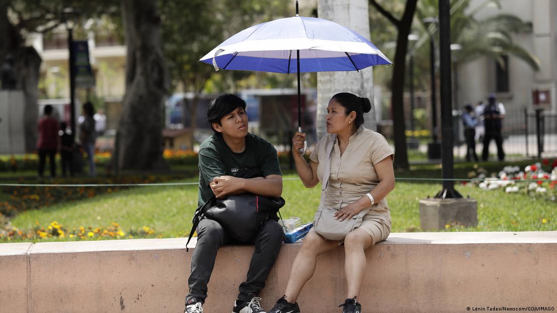 Dos personas bajo una sombrilla.