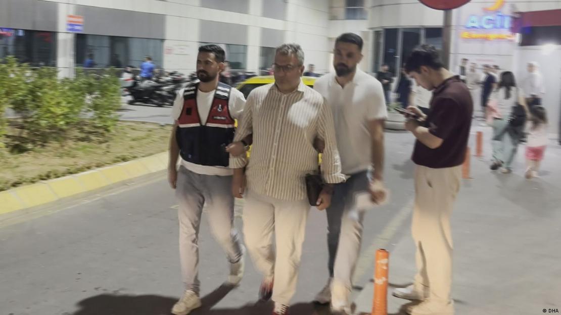 Cem Küçük koluna giren iki polis memuruyla gözaltına alınırken