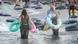Mujeres en playa, vestidas y con flotadores.