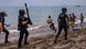 Tres agentes de policía en la playa.