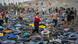 Miles de flotadores en la arena. Alrededor muchas personas.