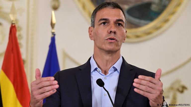 İspanya Başbakanı Pedro Sanchez iki eli havada önündeki mikrofona konuşurken