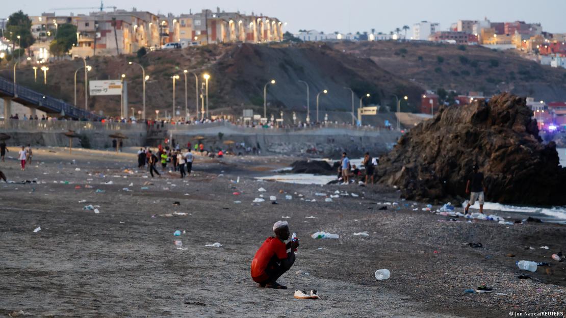 Yaklaşık 84 bin nüfusa sahip Ceuta'ya Fas'tan çoğu genç erkek yaklaşık 60 bin göçmenin akın etmesiyle İspanya toprağı küçük bölgede karmaşa meydana geldi. Genç olduğu görünen bir göçmen sahilde diz çökmüş olarak görülüyor