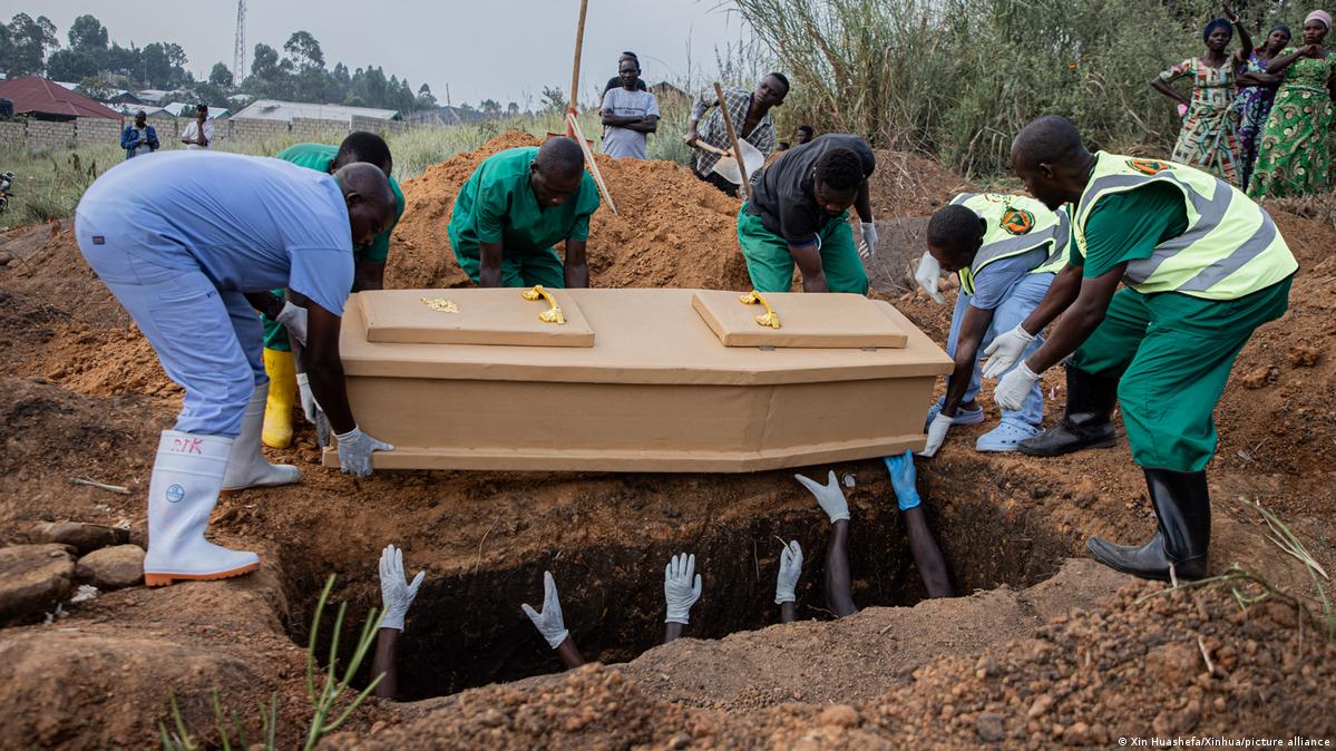 Several men are seen burrying a coffin outside Kinshasa