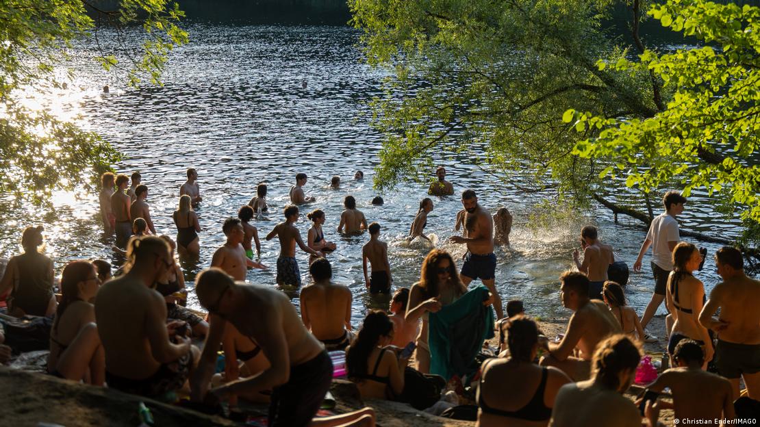 Muitas pessoas se refrscam em um lago em Berlim