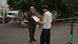 Haraldur Olafsson hands a piece of paper to a person dressed in a white jumper and black pants