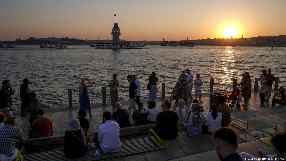 Üsküdar Salacak kıyısında oturan ve yürüyüş yapan vatandaşlar. Güneşin batışında Kız Kulesi manzarası  