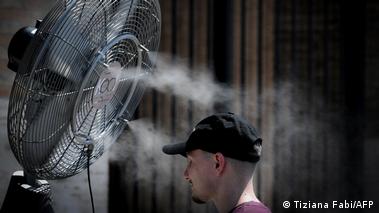 Image 7: A man stands in front of a giant fan, Rome, Italy