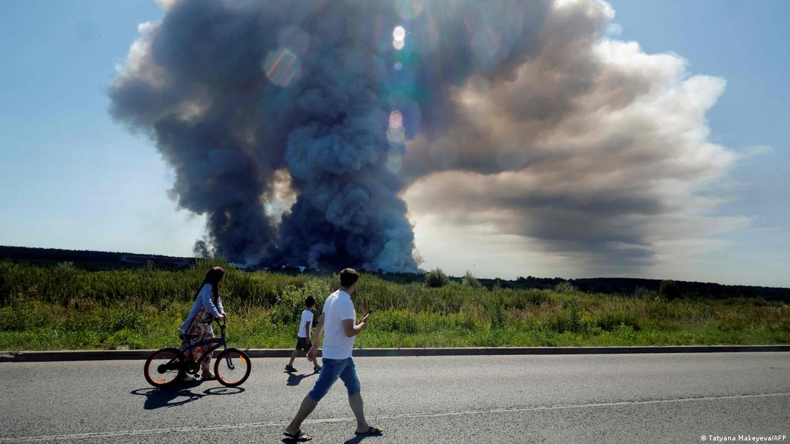 Personas pasan por una ruta, y en el horizonte se ve un iIncendio en el centro logístico de Wildberries tras un ataque con drones ucranianos. (18.07.2026). Personas pasan por una ruta, y en el horizonte se ve un iIncendio en el centro logístico de Wildberries tras un ataque con drones ucranianos. (18.07.2026).