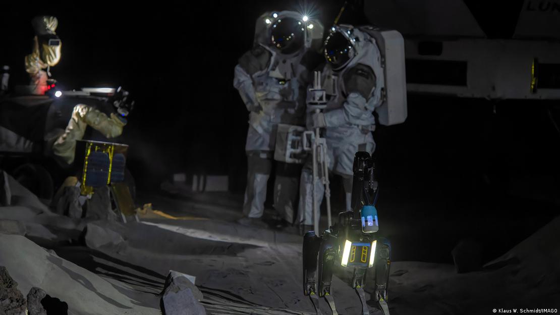 Astronautas y perro robot.