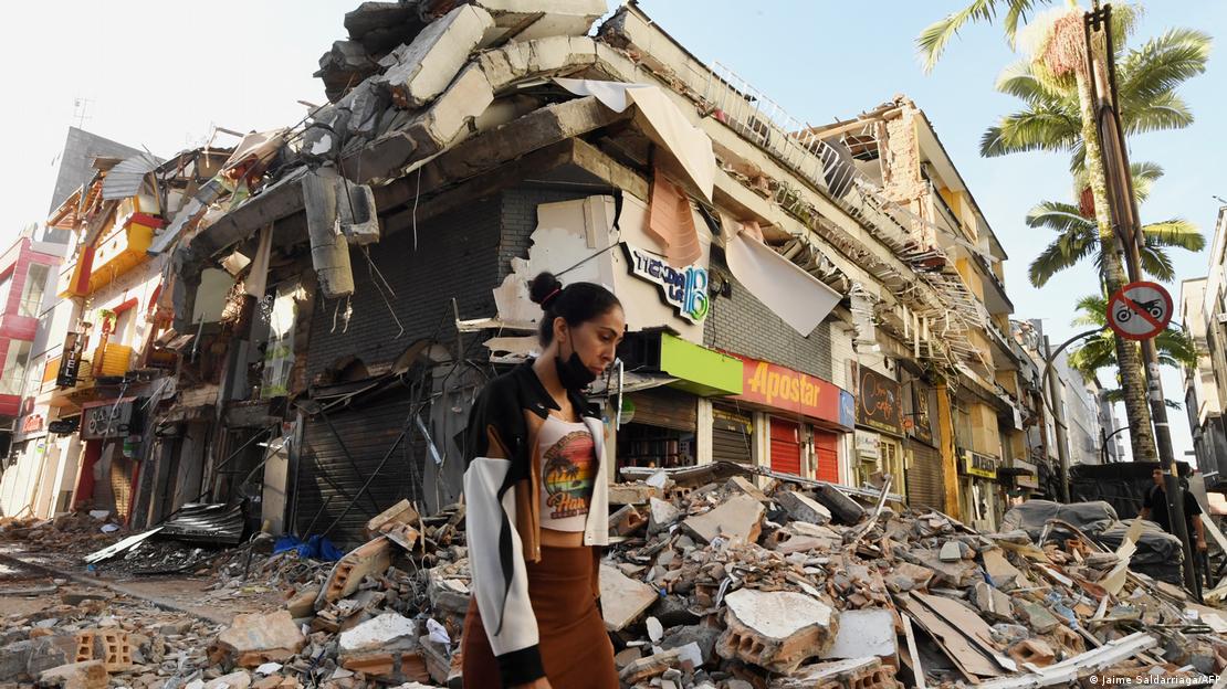 Pereira, Colombia, 2026: una mujer camina junto a los escombros de un edificio derrumbado.