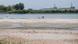 People cool off in the extremely low waters of the Danube near Paks, Hungary, with the Paks Nuclear Power Plant visible in the background on August 9, 2026.