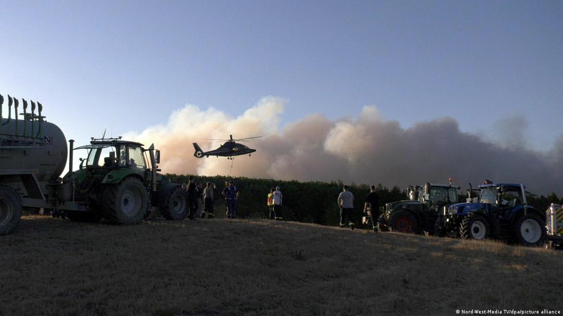 Helicóptero extintor de incendios sobrevuela el incendio en Hürtgenwald, región de Eifel, en Alemania. Helicóptero extintor de incendios sobrevuela el incendio en Hürtgenwald, región de Eifel, en Alemania.