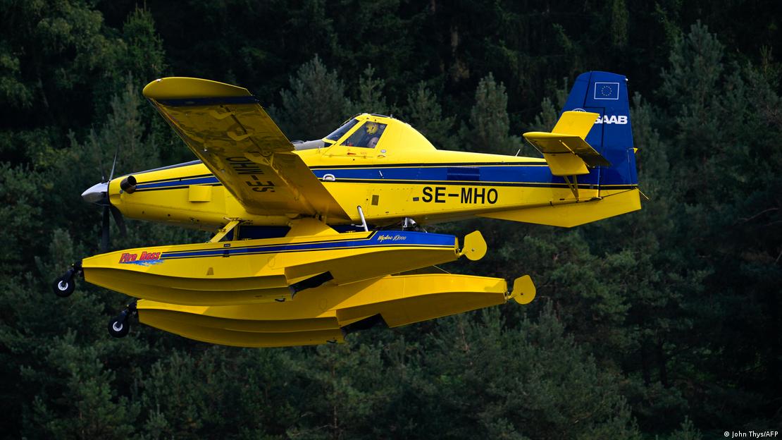 Un SE-MHO AT-802A antiincendios vuela sobre el bosque belga para lanzar su carga de agua. Un SE-MHO AT-802A antiincendios vuela sobre el bosque belga para lanzar su carga de agua.