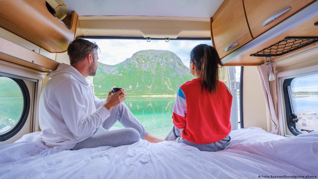 Lofoten 2024 | Dy persona duke pirë kafe dhe duke shikuar në një liqen Lofoten 2024 | Dy persona duke pirë kafe dhe duke shikuar në një liqen