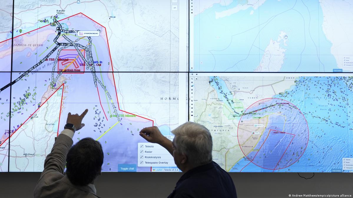 Two UKMTO analysts look at maps of shipping lanes and traffic in the Middle East at the Royal Navy's monitoring center in Portsmouth, UK