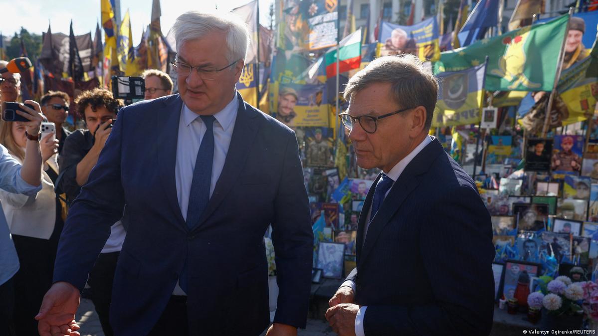 Ukrainian Foreign Minister Andrii Sybiha and German Foreign Minister Johann Wadephul visit a makeshift memorial for fallen Ukrainian defenders at the Independence Square