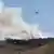 En la imagen se observa un helicóptero que lanza agua al incendio forestal.