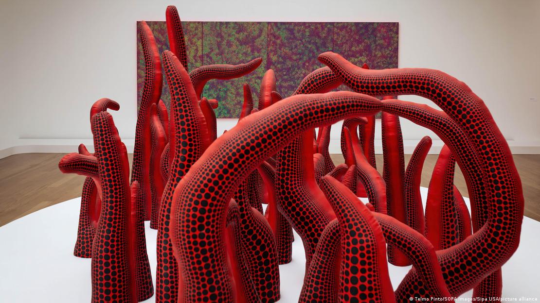 Esculturas de color rojo con puntos negros que recuerdan a tentáculos en una sala del museo; detrás se ve un cuadro colgado en la pared.