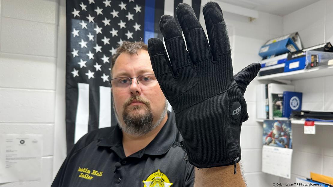 A prison staff in Nelson County shows an electric shock glove that is used at his facility