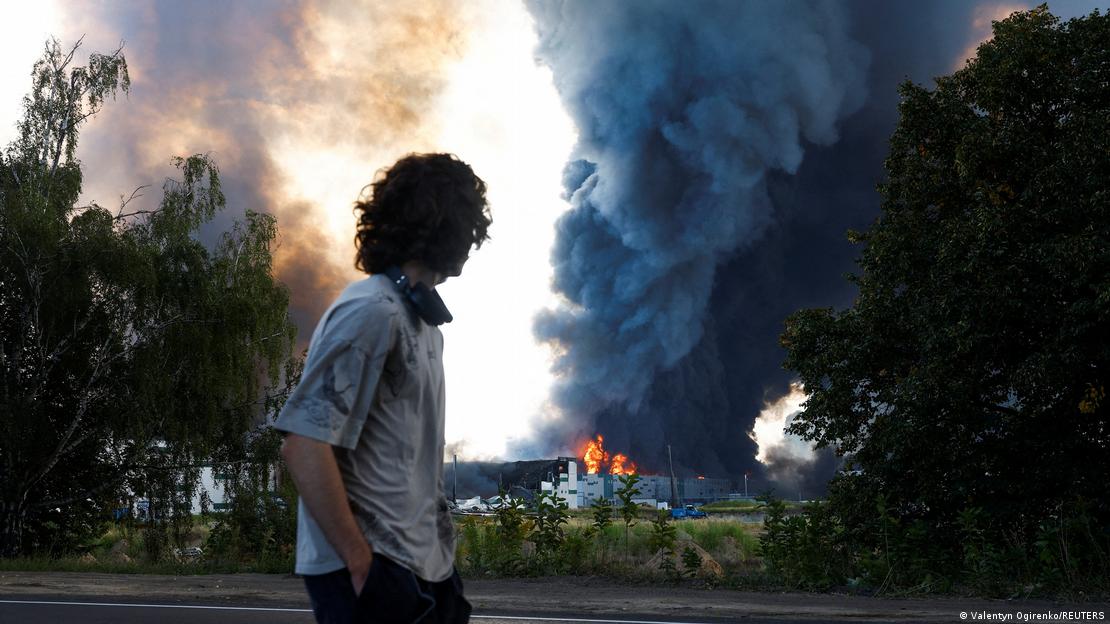 Jovem observa à distância incêndio no depósito de armas alvo de ataque russo