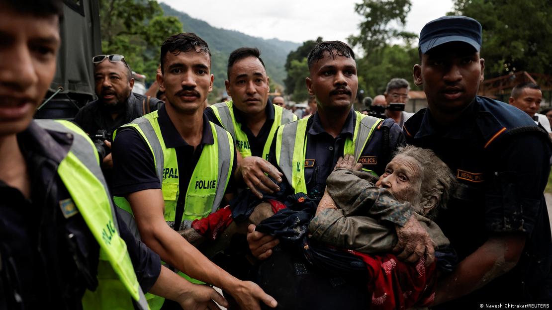 Policiais nepaleses carregam sobrevivente após inundação