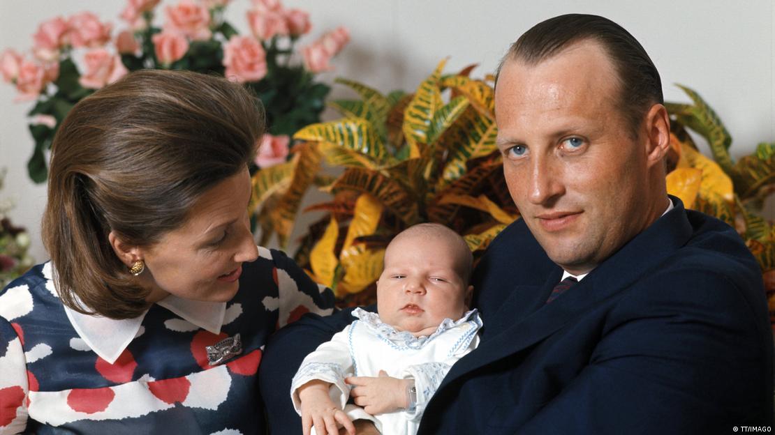 O rei Haakon 8º como bebê nos braços dos pais, à época príncipe Harald e princesa Sonja