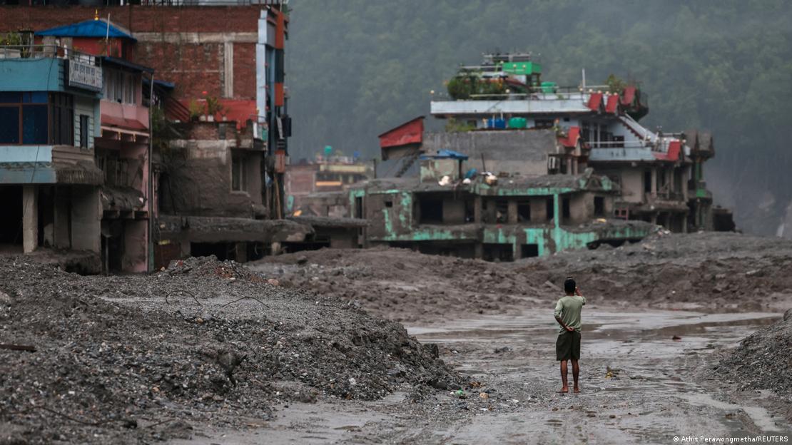 Pessoa observa edifícios destruídos pelas enchentes em Trishuli, no Nepal Pessoa observa edifícios destruídos pelas enchentes em Trishuli, no Nepal