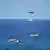 Kıbrıs açıklarında deniz yüzeyinde can kurtarma botları, arka planda bir helikopter ve Sahil Güvenlik teknesi
