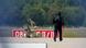 A police officer in protective clothing walks next to an explosive-disarming robot (EOD) at Leipzig/Halle Airport, Germany, August 5, 2026