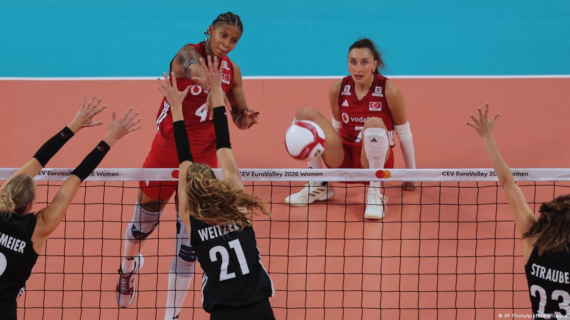Melissa Vargas'ın vurduğu smacı karşılamaya çalışan Alman voleybolcular. Pozisyon icabı yerde kalan Hande Baladın arka planda bu anı izliyor. Melissa Vargas'ın vurduğu smacı karşılamaya çalışan Alman voleybolcular. Pozisyon icabı yerde kalan Hande Baladın arka planda bu anı izliyor.