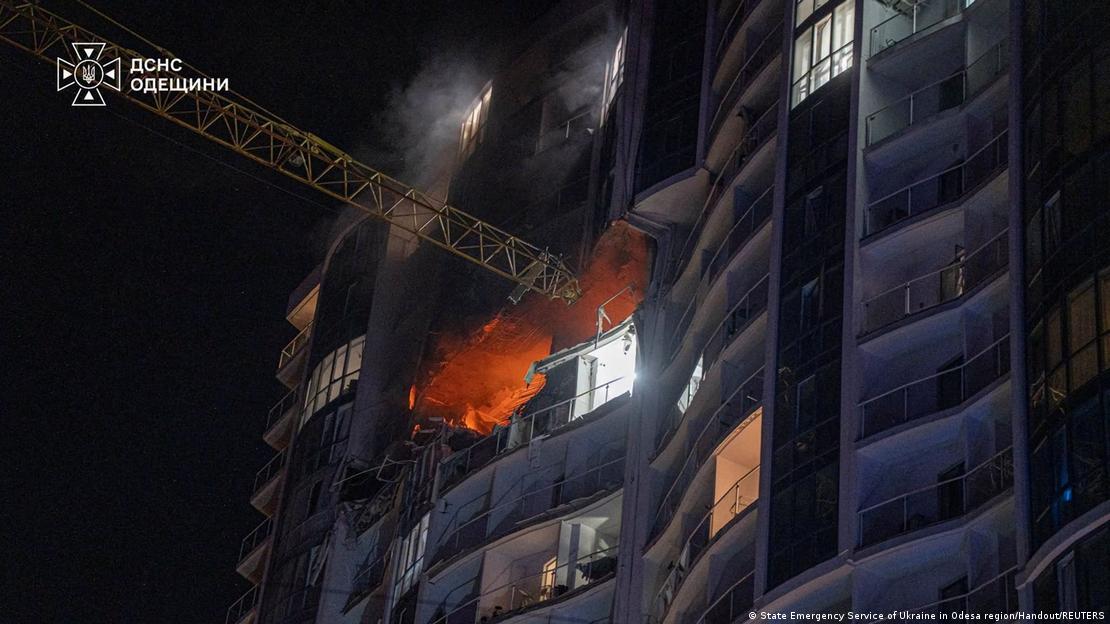 Una grúa junto al edificio dañado todavía de noche. Una grúa junto al edificio dañado todavía de noche.