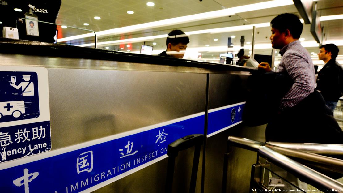 A man has his passport checked at the immigration control, at Shanghai Pudong International Airport, in Shanghai, China, on March 15, 2018 Паспорт мужчины сдают на иммиграционном контроле в международном аэропорту Шанхай Пудун в Шанхае, Китай, 15 марта 2018 года