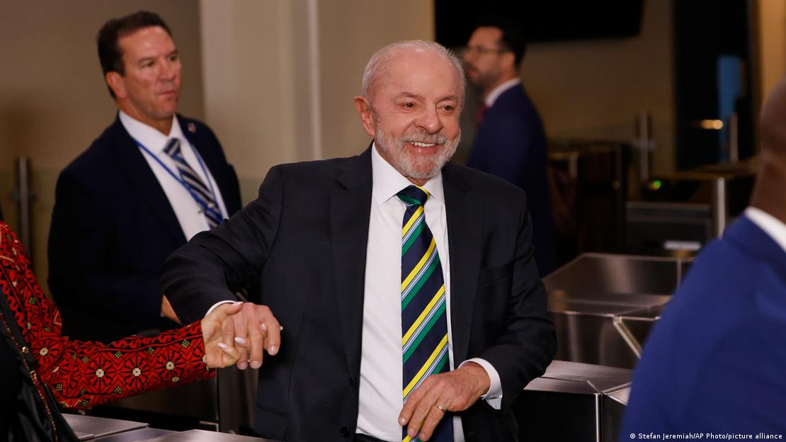Lula da Silva sonríe. Está dando de la mano a una mujer.
