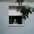 Idosa observa da janela de seu apartamento em Madri um protesto contra o despejo de uma senhora de 87 anos