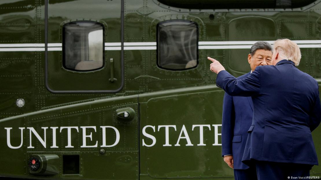Donald Trump conversa con Xi Jinping junto al helicóptero mientras lo señala con el dedo.