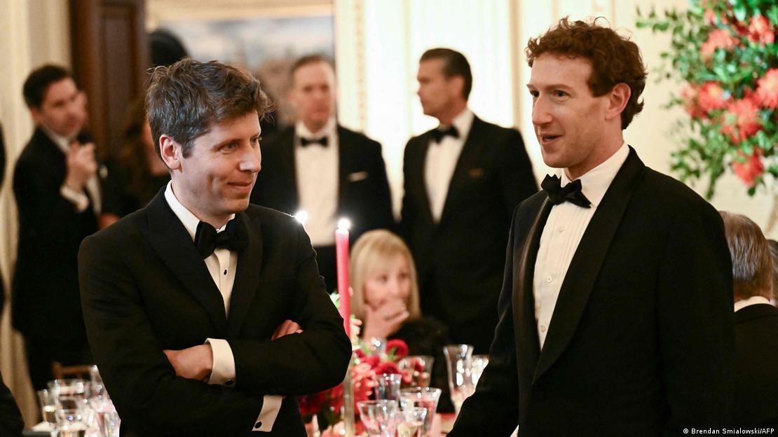 Sam Altman (solda) ve Mark Zuckerberg (sağda) yan yana ayakta duruyor. Arkalarında smokinli kişiler var Sam Altman (solda) ve Mark Zuckerberg (sağda) yan yana ayakta duruyor. Arkalarında smokinli kişiler var