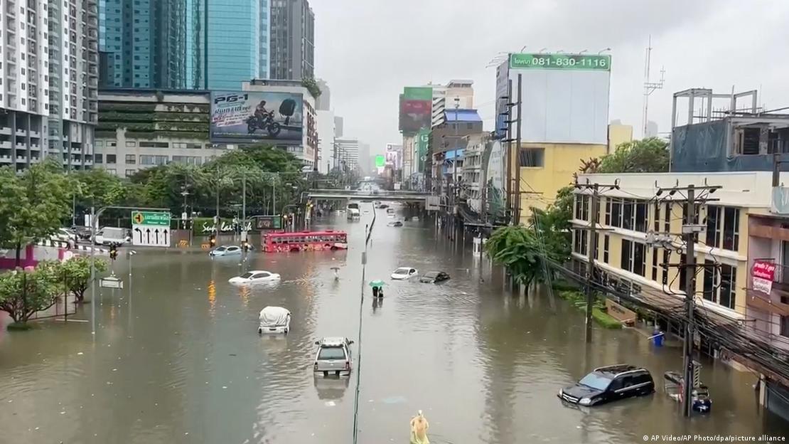 A flooded street scene in Bangkok showing abandoned cars in flood water
