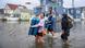 Image 8: Wildwood, USA, 2026 | Family with their belongings on a flooded street after a Nor'easter storm